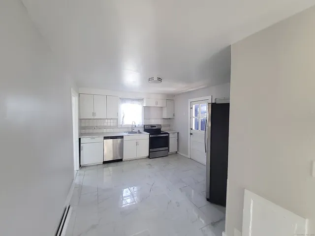 a large kitchen with a sink and cabinets