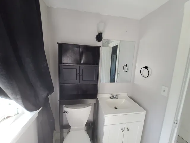 a bathroom with a toilet sink and mirror