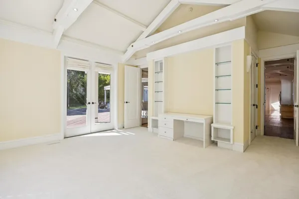 an empty room with a cabinet and mirrors