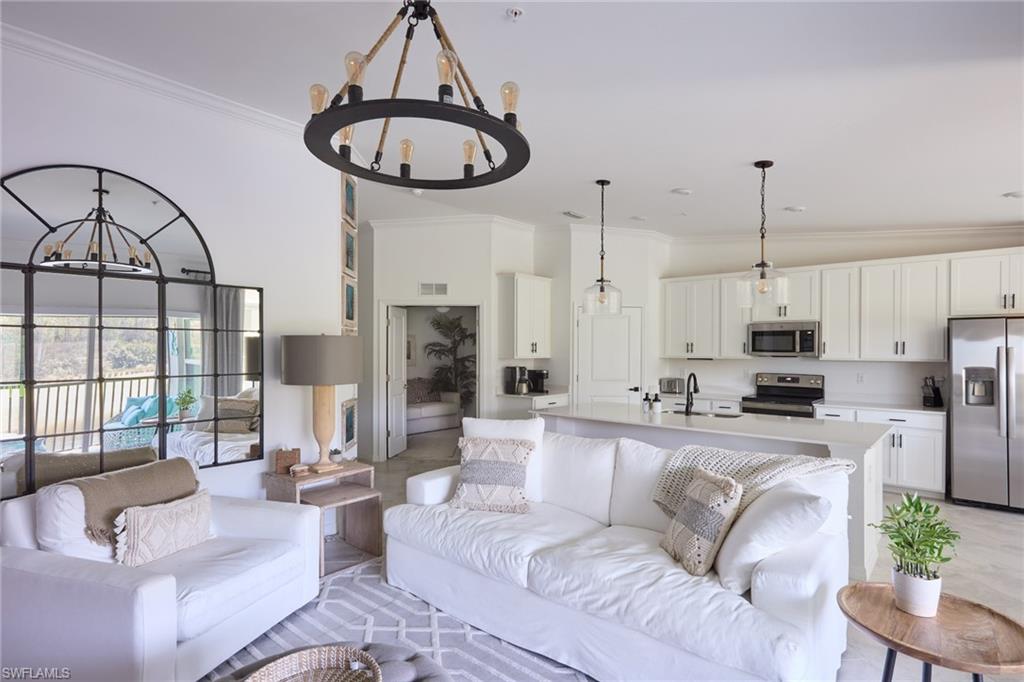 6070 National Blvd Avenue, Unit 226 Immokalee, FL 34142 - Photo 14 of 47 a living room with furniture a fireplace and a chandelier