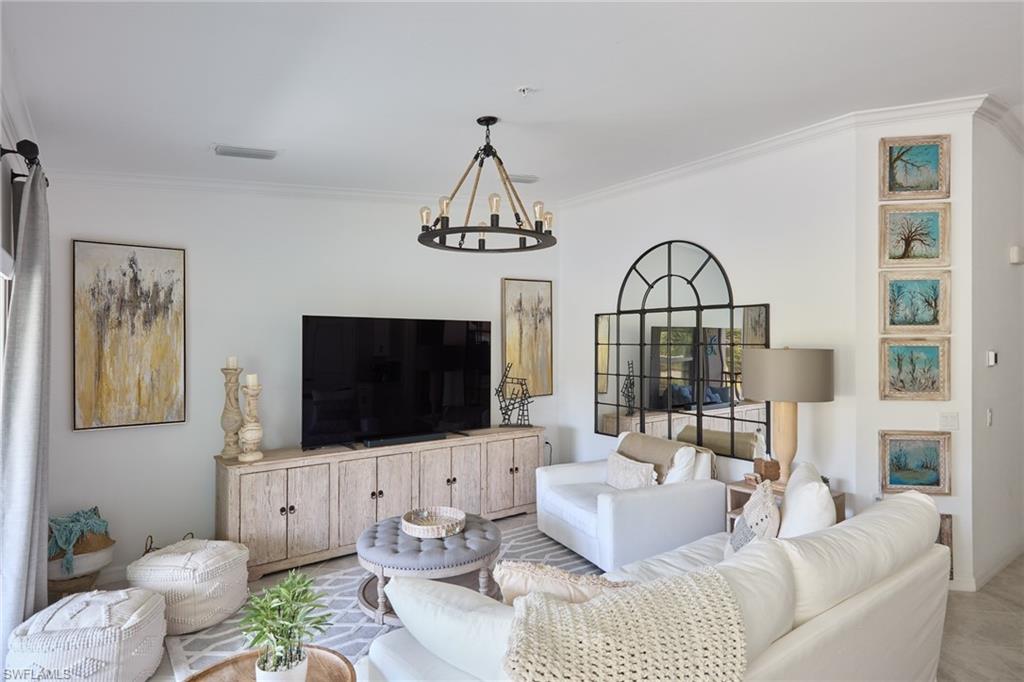 6070 National Blvd Avenue, Unit 226 Immokalee, FL 34142 - Photo 15 of 47 a living room with furniture a flat screen tv and a view of kitchen