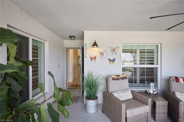 a living room with furniture potted plant and a large window