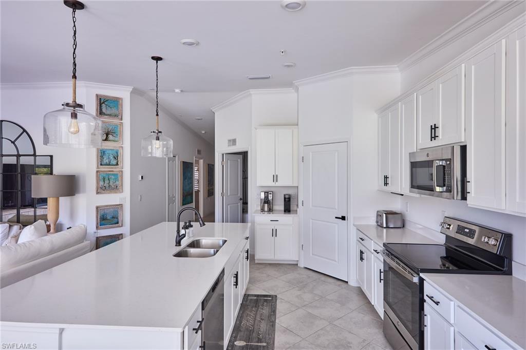 6070 National Blvd Avenue, Unit 226 Immokalee, FL 34142 - Photo 10 of 47 a kitchen with stainless steel appliances sink stove microwave and refrigerator