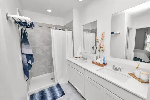 a bathroom with a double vanity sink and a mirror