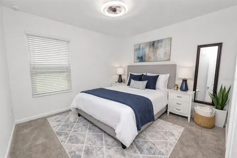 a bedroom with a large bed and a potted plant