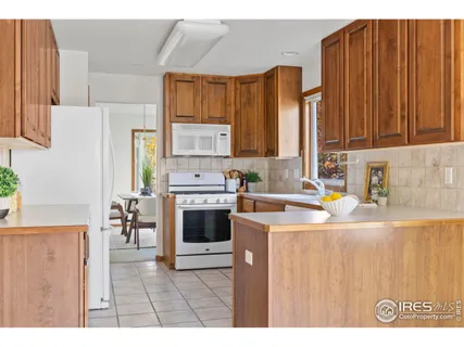 a kitchen with stainless steel appliances a stove a sink a refrigerator a dining table and chairs