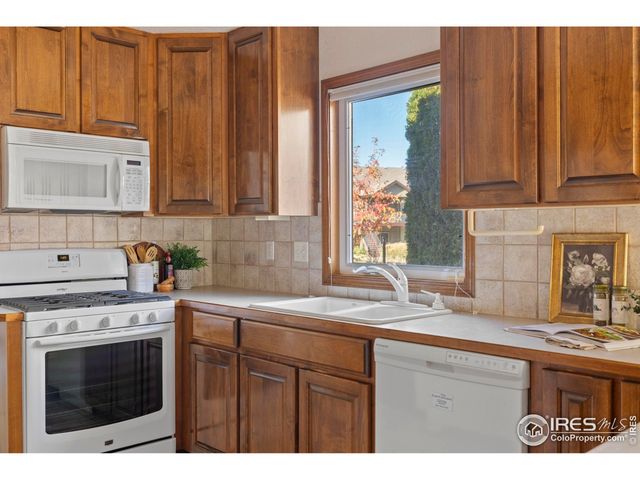 a kitchen with stainless steel appliances granite countertop a sink a stove and a microwave
