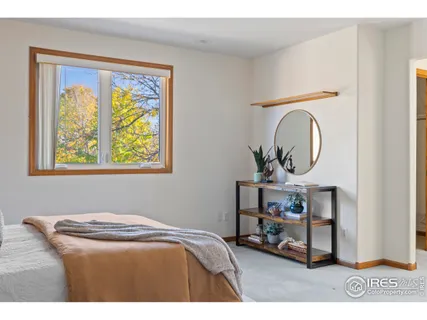 a bedroom with a bed a mirror and a window