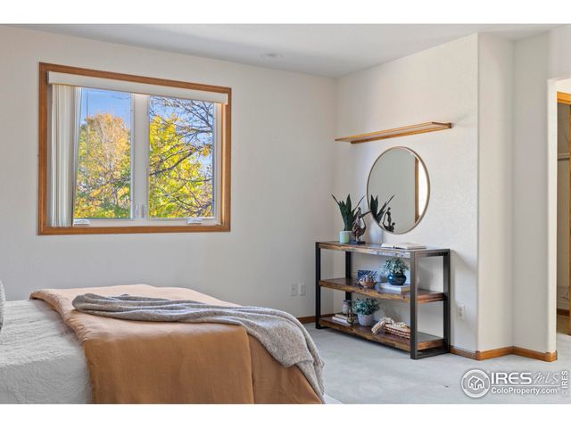 a bedroom with a bed a mirror and a window