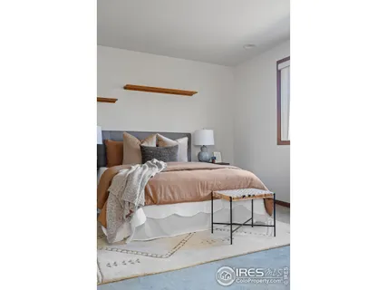 a bedroom with a bed and a wall painting