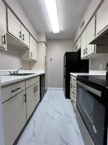 a kitchen with stainless steel appliances kitchen island a sink stove and cabinets