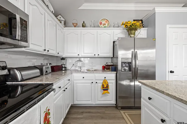 a kitchen with a sink a refrigerator and cabinets