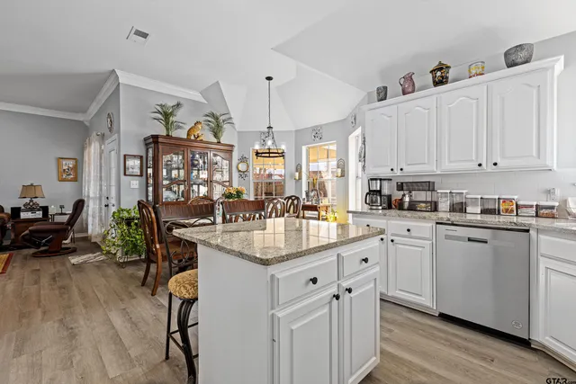 a kitchen with granite countertop a sink stove and cabinets