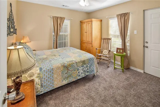 a bed sitting in a spacious bedroom next to a window