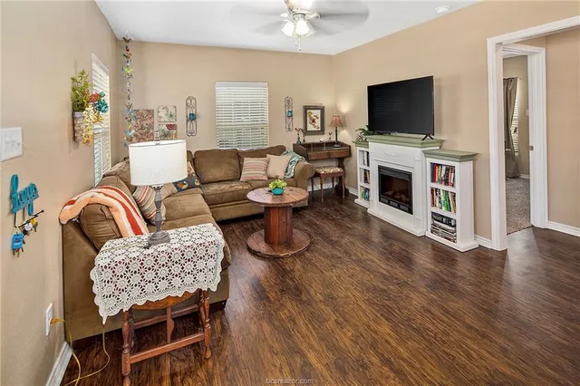 a living room with furniture a flat screen tv and a fireplace