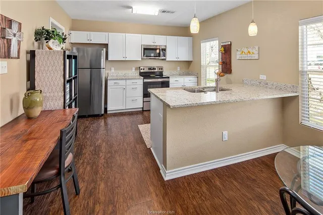 a kitchen with refrigerator cabinets and wooden floor