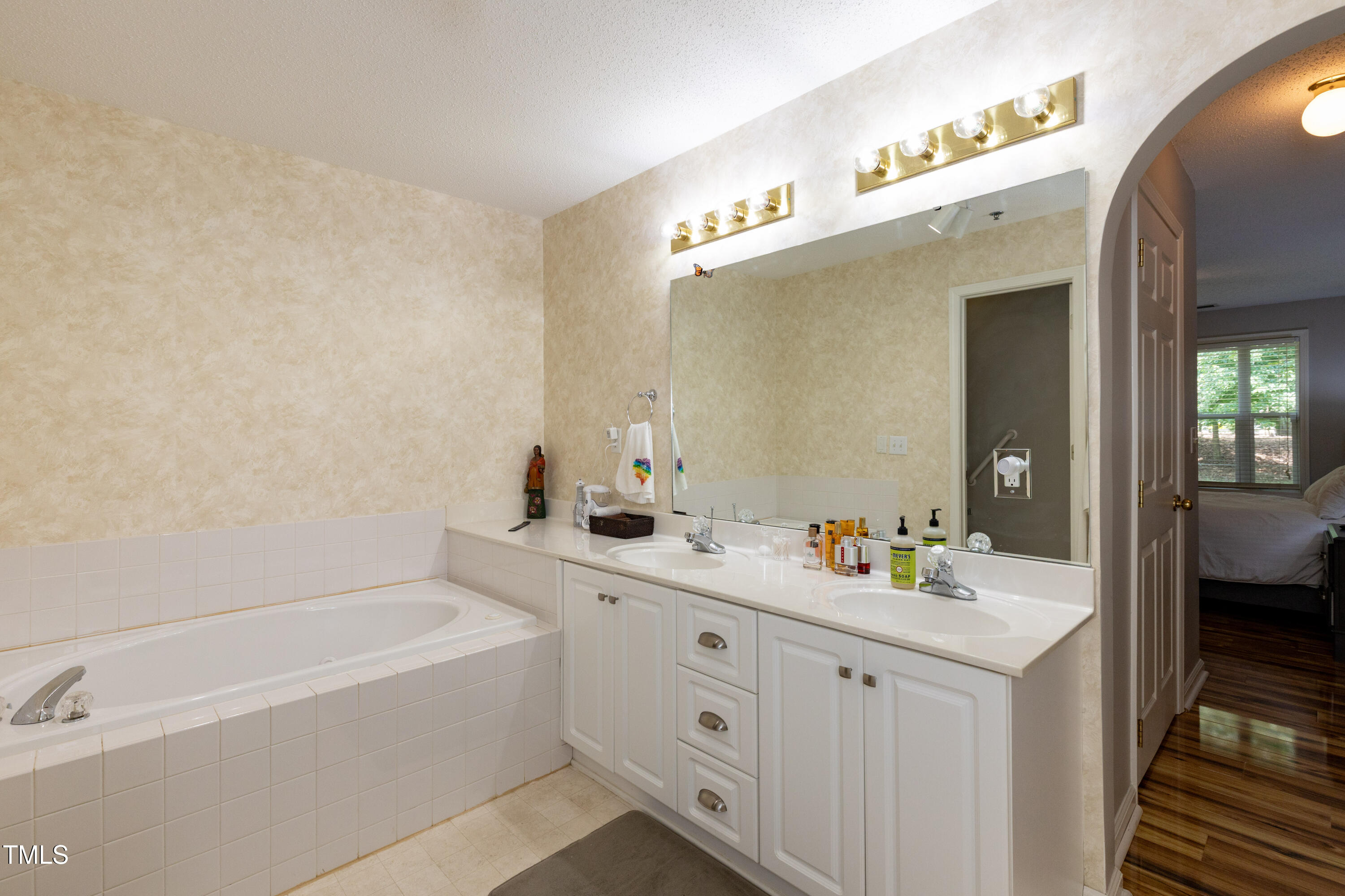 1911 Falls Landing Drive, Unit 103 Raleigh, NC 27614 - Photo 14 of 28 a en suite bathroom with a double vanity sink and mirror