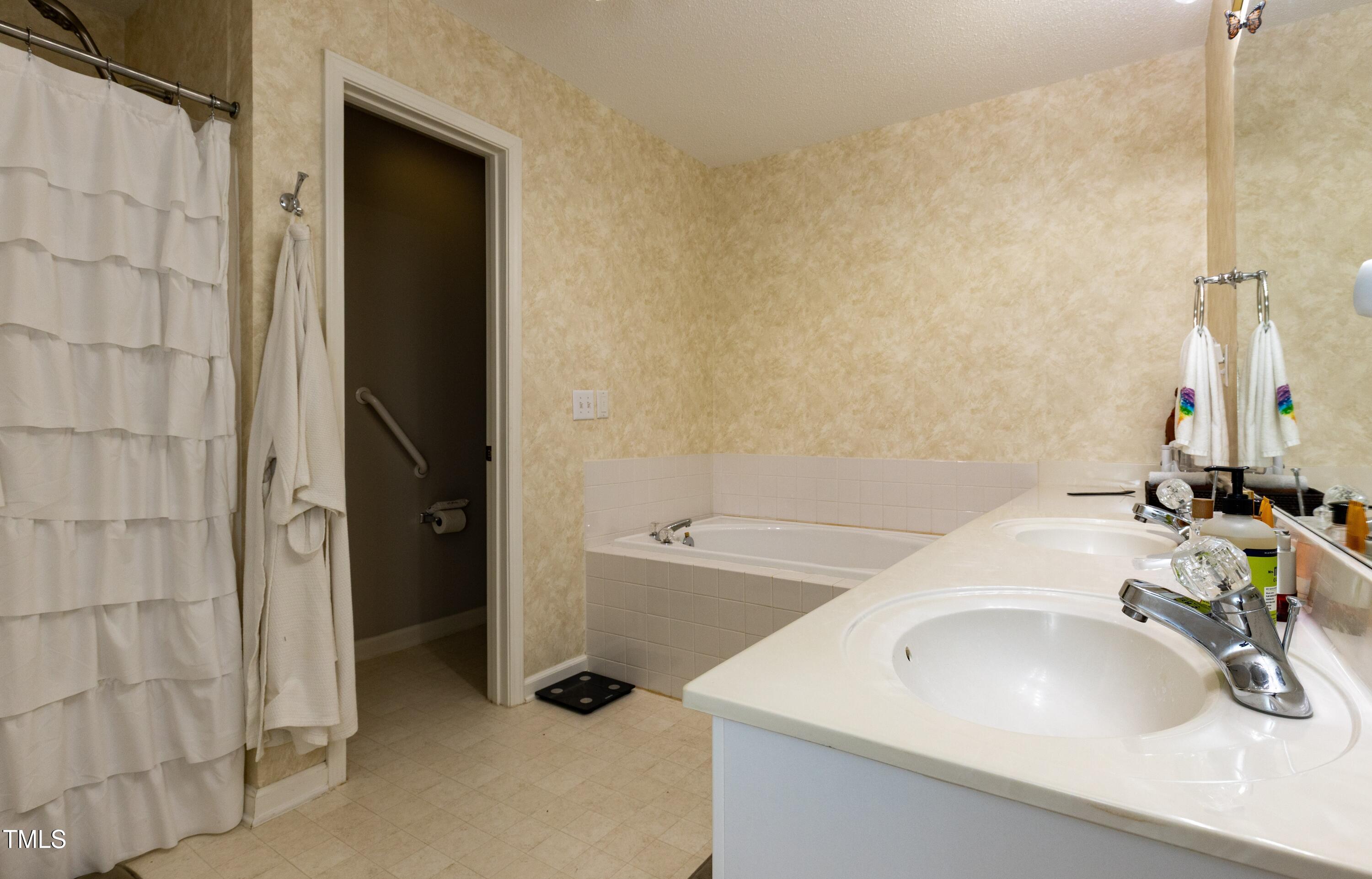 1911 Falls Landing Drive, Unit 103 Raleigh, NC 27614 - Photo 15 of 28 a bathroom with a sink and a tub