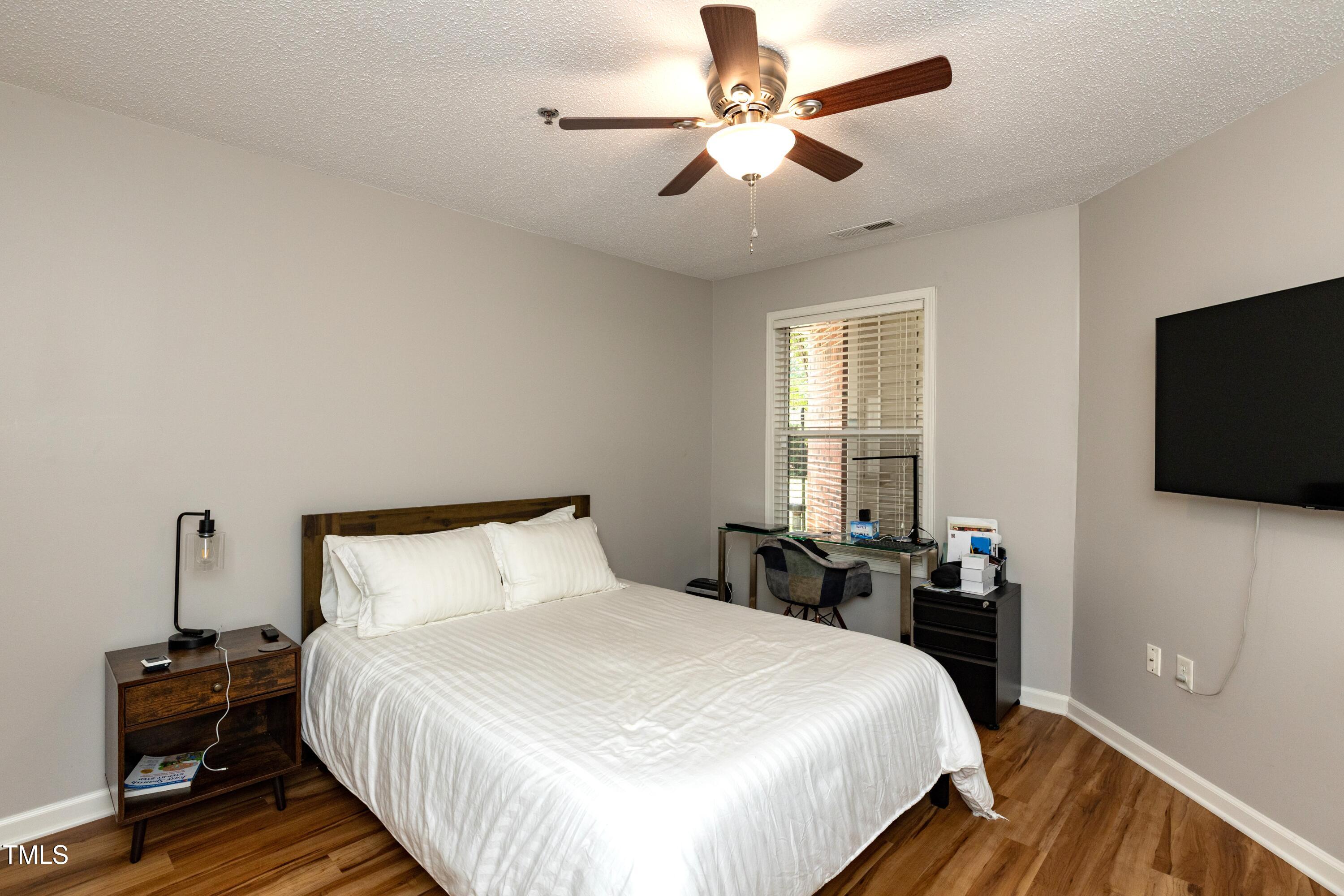 1911 Falls Landing Drive, Unit 103 Raleigh, NC 27614 - Photo 18 of 28 a bedroom with a bed and a flat screen tv