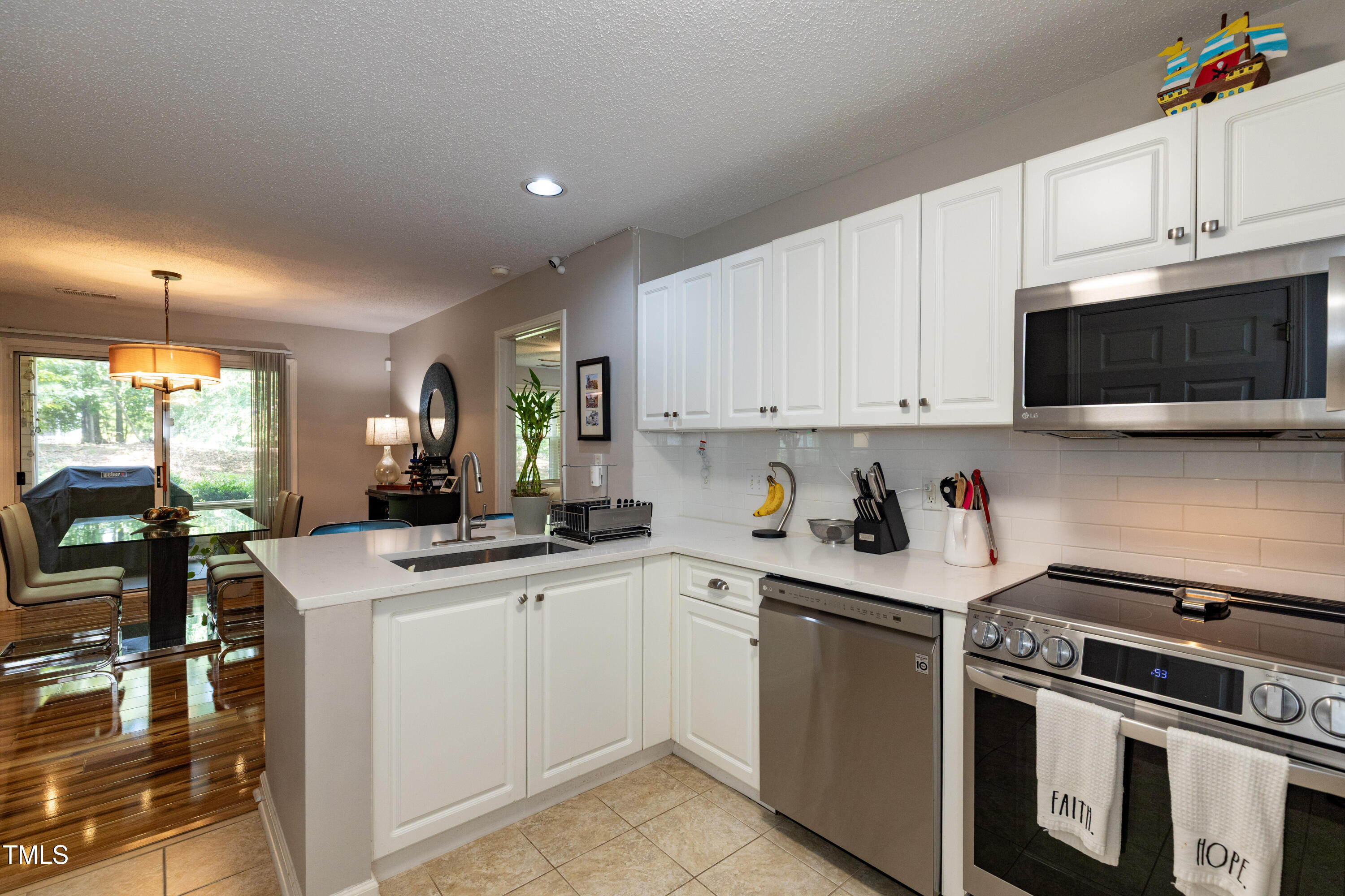 1911 Falls Landing Drive, Unit 103 Raleigh, NC 27614 - Photo 2 of 28 a kitchen with granite countertop a sink a stove and cabinets