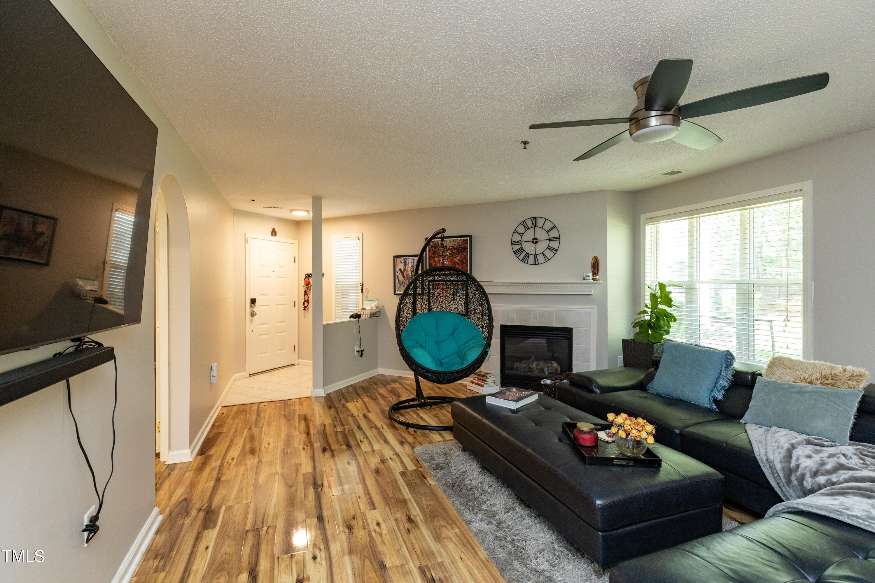 1911 Falls Landing Drive, Unit 103 Raleigh, NC 27614 - Photo 5 of 28 a living room with furniture a fireplace and a flat screen tv