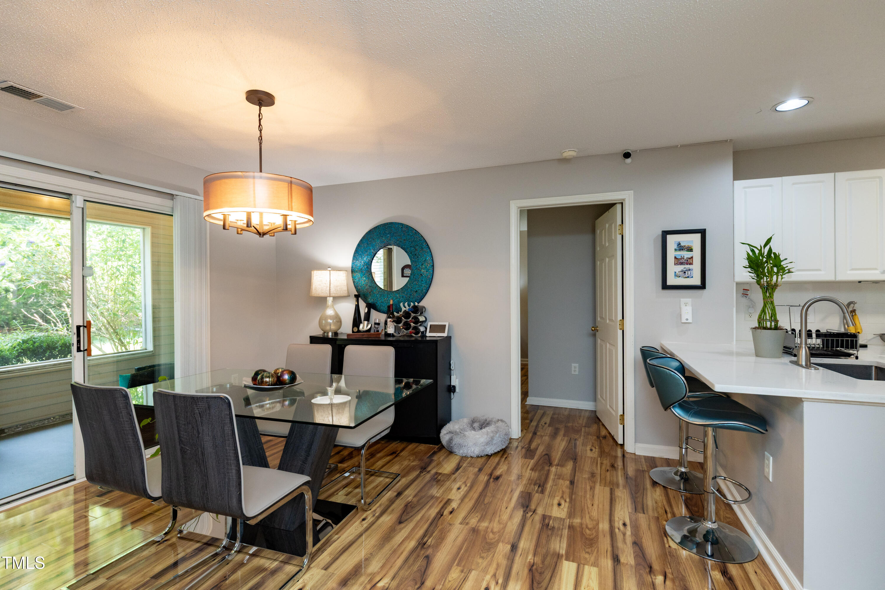 1911 Falls Landing Drive, Unit 103 Raleigh, NC 27614 - Photo 6 of 28 a view of a dining room with furniture a chandelier and wooden floor