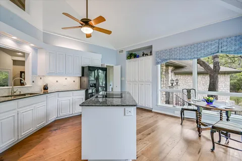 a kitchen with cabinets a sink dining table and chairs