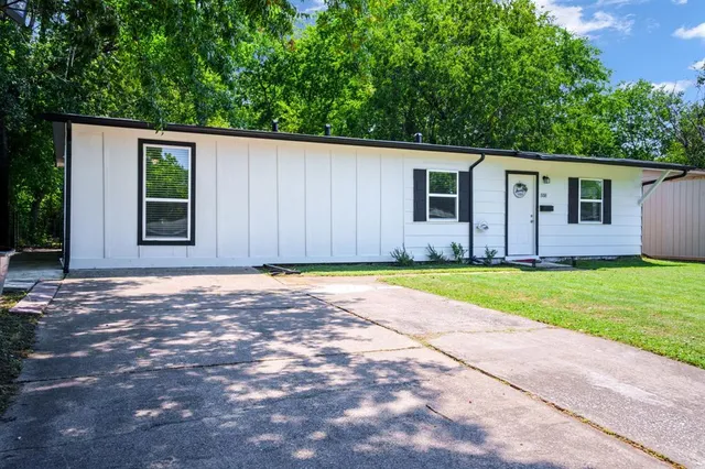 a view of a house with backyard and tree
