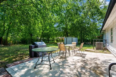 a backyard of a house with table and chairs