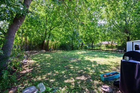 a backyard of a house with lots of green space and fountain