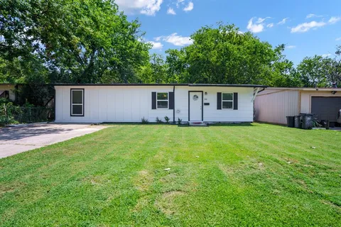 a view of house with backyard and trees