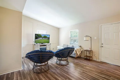a living room with furniture a table and wooden floor