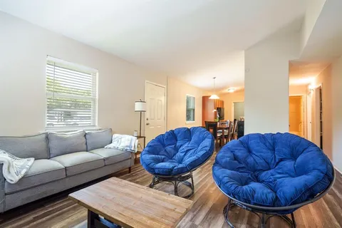 a living room with furniture a rug and a chandelier