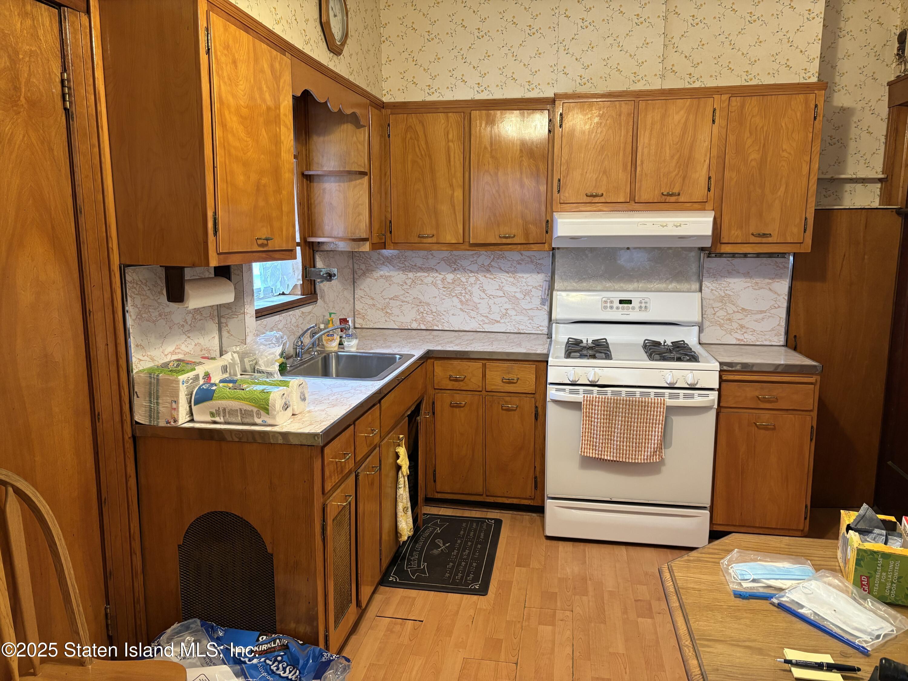 9105 Ridge Boulevard Brooklyn, NY 11209 - Photo 4 of 12 a kitchen with a sink a stove cabinets and wooden floor