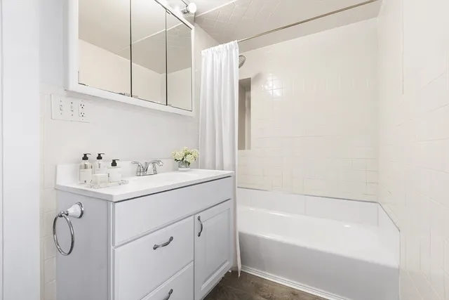 a bathroom with a sink vanity tub and shower