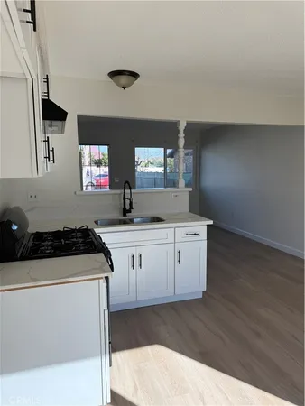 a kitchen with granite countertop a stove a sink and a microwave