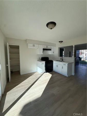 a large white kitchen with a stove a sink dishwasher and a refrigerator