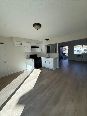 a large kitchen with stainless steel appliances kitchen island a large counter top and a wooden floors