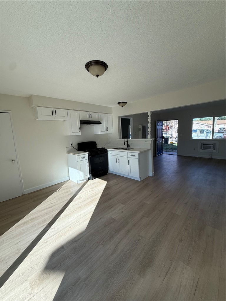 558 South Benjamin Street Rialto, CA 92376 - Photo 16 of 25 a large kitchen with stainless steel appliances kitchen island a large counter top and a wooden floors