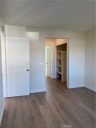 an empty room with wooden floor and closet