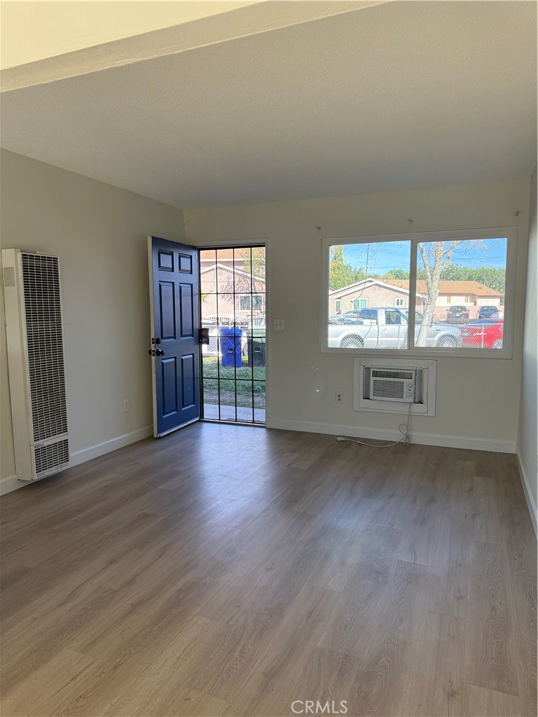 558 South Benjamin Street Rialto, CA 92376 - Photo 5 of 25 an empty room with wooden floor and windows