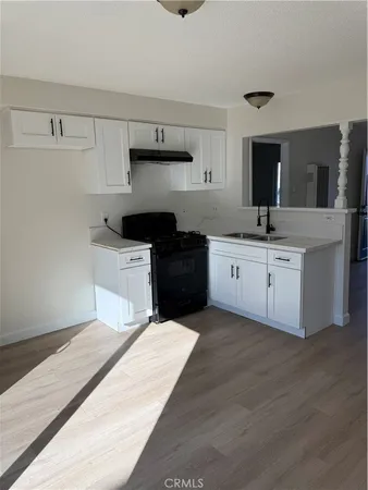 a kitchen with a sink a stove and cabinets