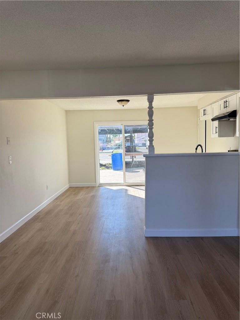 558 South Benjamin Street Rialto, CA 92376 - Photo 8 of 25 a view of a kitchen with a fridge and wooden floor