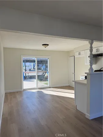 a view of empty room with wooden floor and window