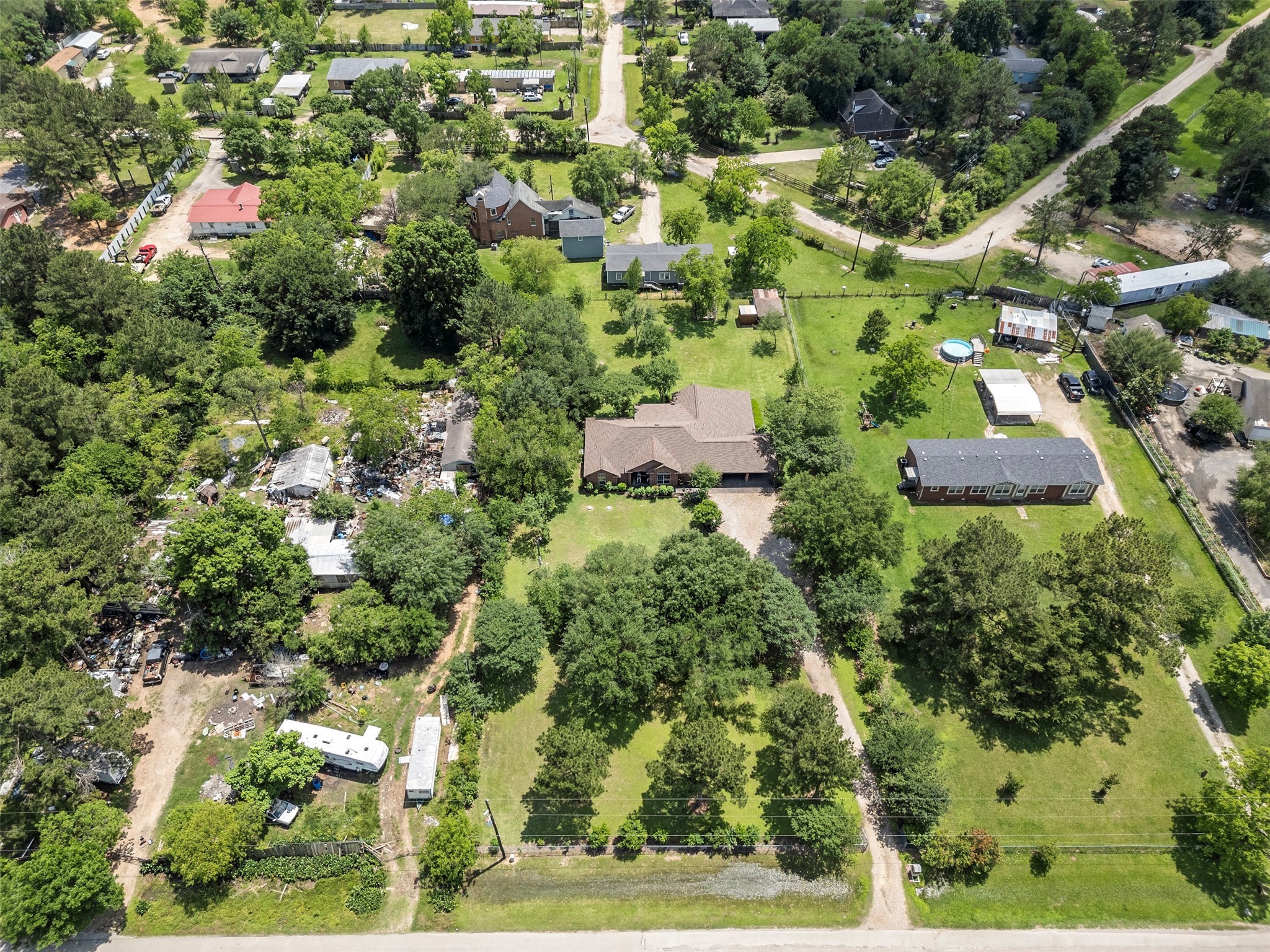 an aerial view of residential houses with outdoor space and trees all around