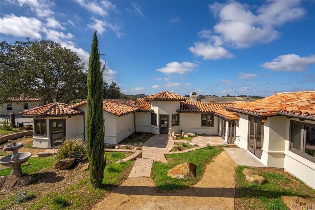 a front view of a house with garden and houses