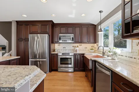 a kitchen with kitchen island granite countertop a sink stove and refrigerator