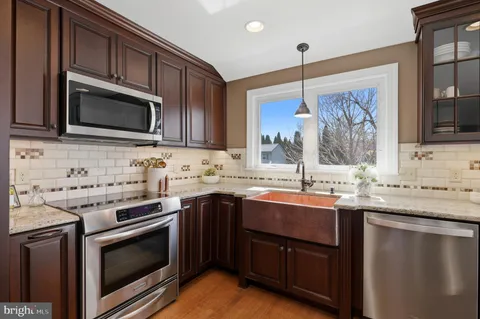 a kitchen with stainless steel appliances granite countertop a sink stove microwave and cabinets