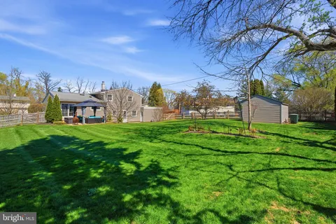 a view of a house with a big yard and large trees