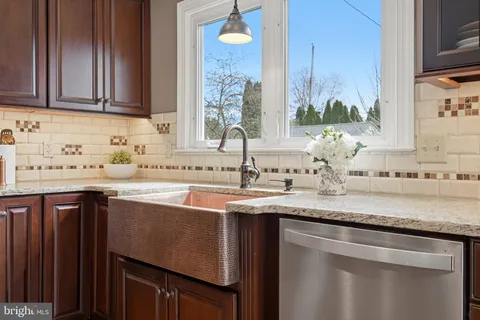 a kitchen with stainless steel appliances granite countertop a sink a stove and a microwave